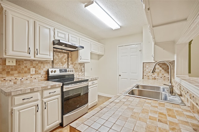 kitchen with sink, decorative backsplash, stainless steel electric stove, and tile counters