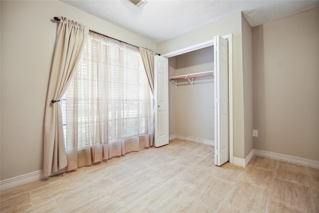 unfurnished bedroom featuring a closet and a textured ceiling