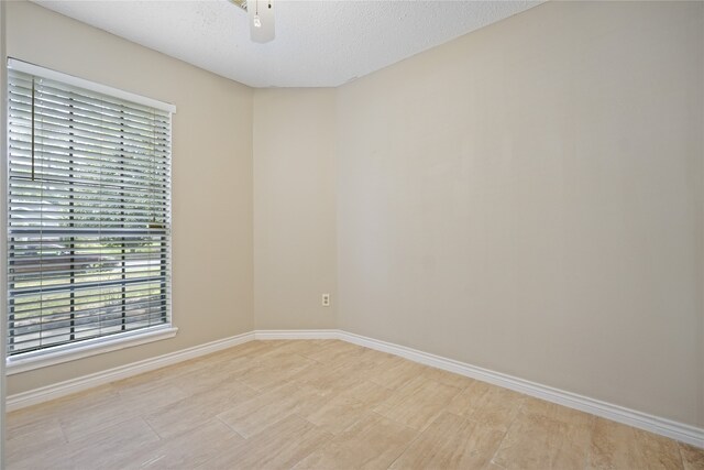 unfurnished room with a textured ceiling and ceiling fan