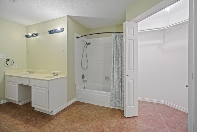 bathroom with vanity, a textured ceiling, shower / bath combination with curtain, and tile patterned floors