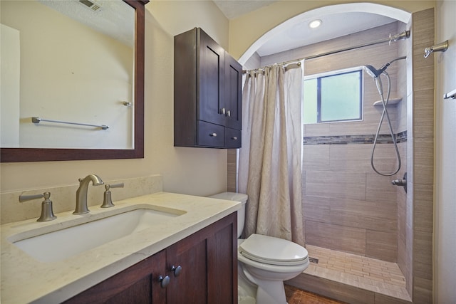 bathroom featuring vanity, a shower with shower curtain, and toilet