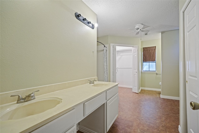 bathroom with vanity, a shower with shower curtain, a textured ceiling, and ceiling fan