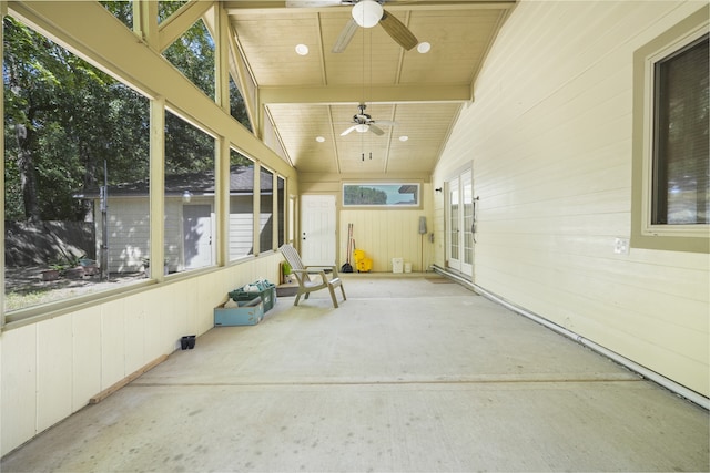 unfurnished sunroom featuring ceiling fan and vaulted ceiling with beams