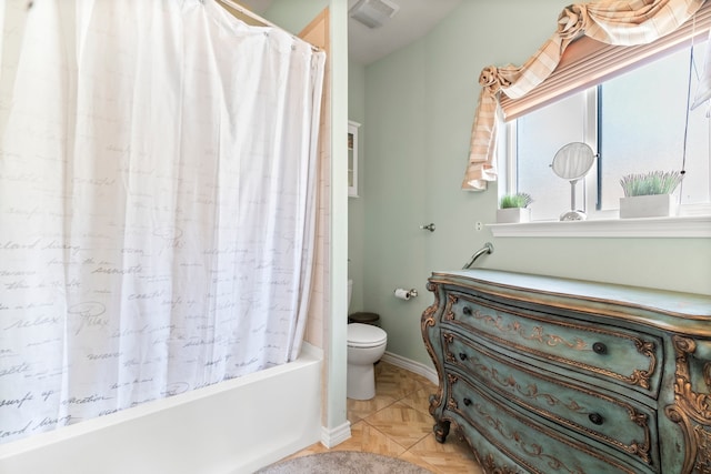 bathroom with toilet, tile patterned floors, and shower / tub combo with curtain