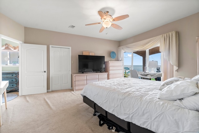 bedroom featuring light carpet, a closet, and ceiling fan