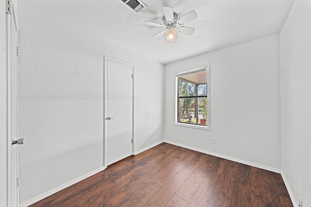 unfurnished bedroom featuring a closet, ceiling fan, and dark hardwood / wood-style flooring