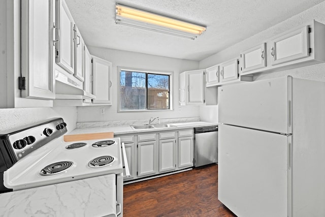 kitchen featuring dark hardwood / wood-style floors, range hood, sink, white cabinets, and white appliances