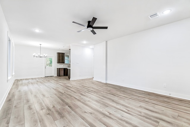 unfurnished living room featuring light wood-type flooring and ceiling fan with notable chandelier