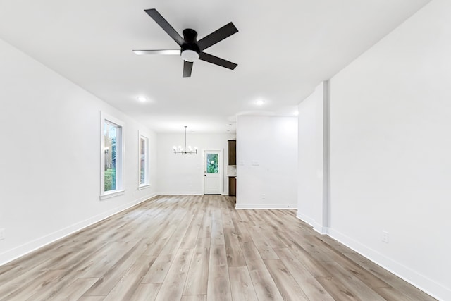 unfurnished living room featuring light hardwood / wood-style floors and ceiling fan with notable chandelier