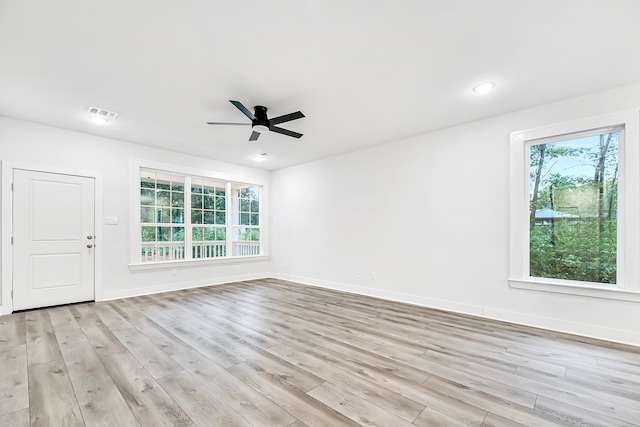 empty room with ceiling fan and light hardwood / wood-style flooring