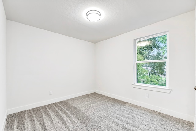 carpeted spare room featuring a textured ceiling