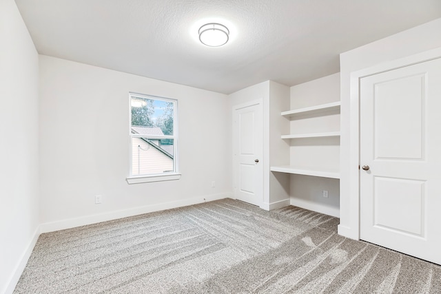 unfurnished bedroom featuring a textured ceiling and carpet floors