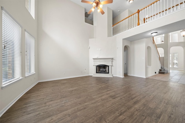 unfurnished living room featuring ceiling fan, plenty of natural light, and hardwood / wood-style floors