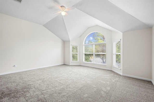 empty room featuring ceiling fan, vaulted ceiling, and carpet