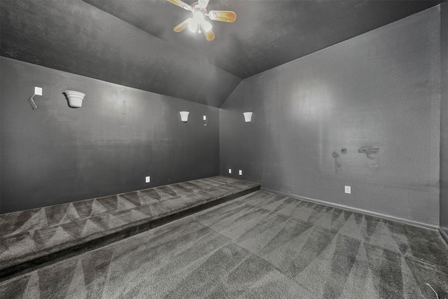 carpeted empty room with vaulted ceiling and ceiling fan