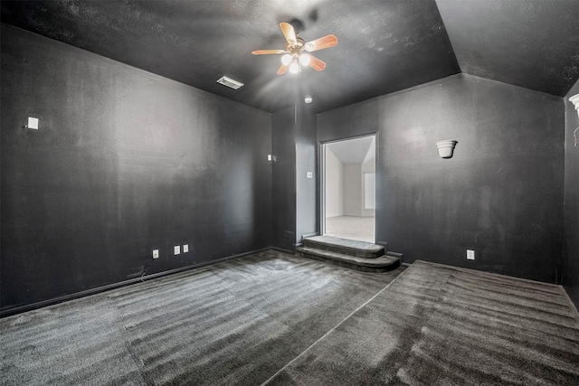 carpeted spare room with ceiling fan and vaulted ceiling