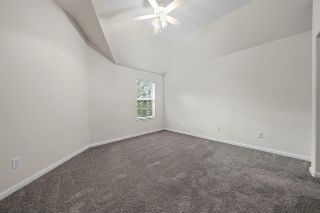 spare room with vaulted ceiling, ceiling fan, and carpet flooring