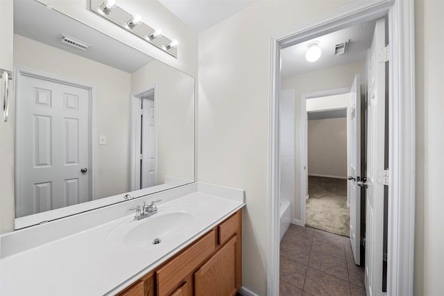 bathroom with tile patterned flooring, vanity, and a tub