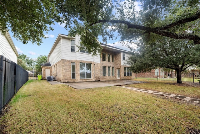 rear view of house featuring cooling unit, a yard, and a patio