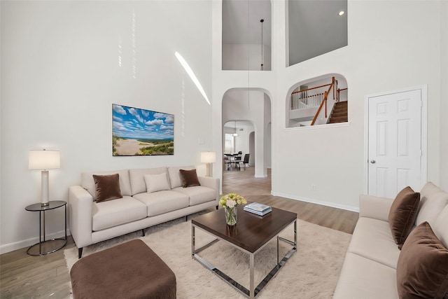 living room featuring wood-type flooring and a towering ceiling