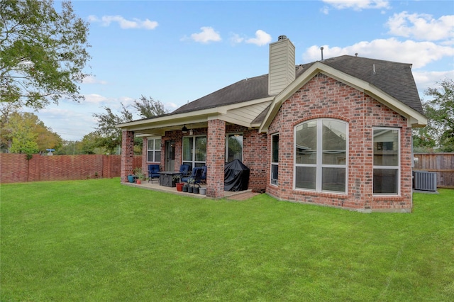 rear view of house featuring a patio area, ceiling fan, a yard, and central AC