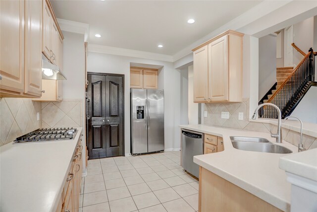 kitchen featuring sink, light brown cabinets, tasteful backsplash, light tile patterned floors, and appliances with stainless steel finishes