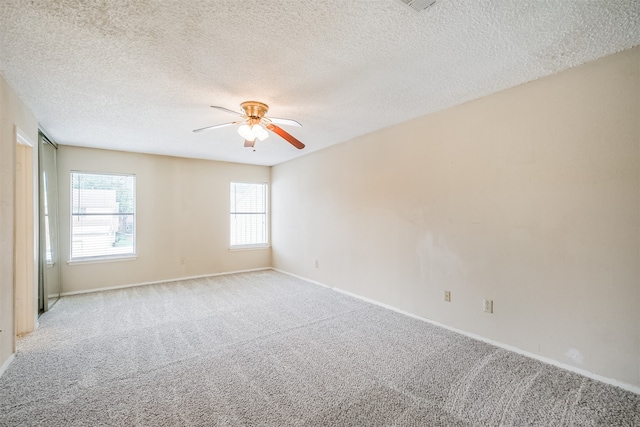 empty room featuring light carpet, a textured ceiling, and ceiling fan