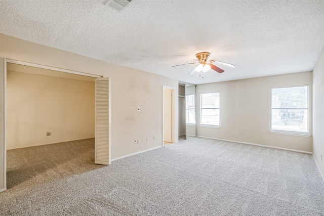 empty room featuring light carpet, a textured ceiling, and ceiling fan