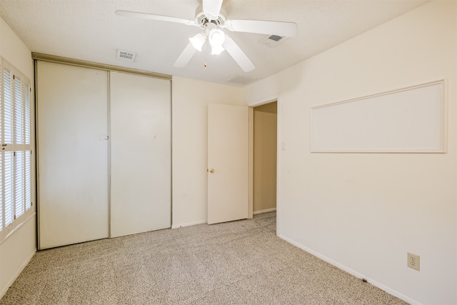 unfurnished bedroom with a closet, ceiling fan, and light carpet