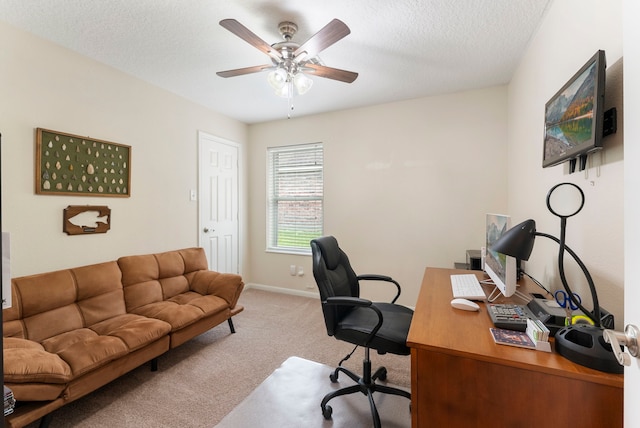 carpeted home office with ceiling fan and a textured ceiling