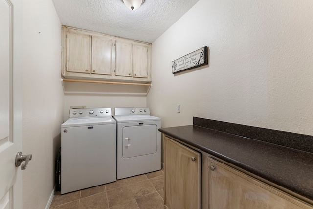 clothes washing area with light tile patterned flooring, a textured ceiling, cabinets, and washing machine and clothes dryer