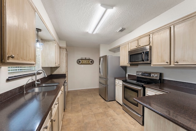 kitchen with decorative light fixtures, stainless steel appliances, sink, and light brown cabinetry