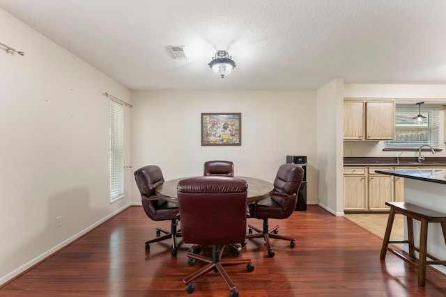 dining room featuring a textured ceiling, sink, and dark hardwood / wood-style flooring