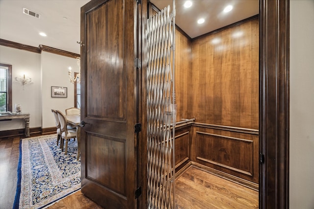 details with hardwood / wood-style flooring and crown molding