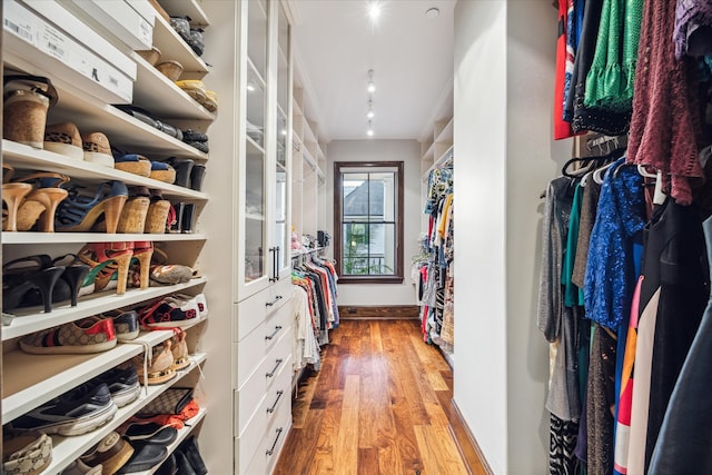 walk in closet with light hardwood / wood-style flooring