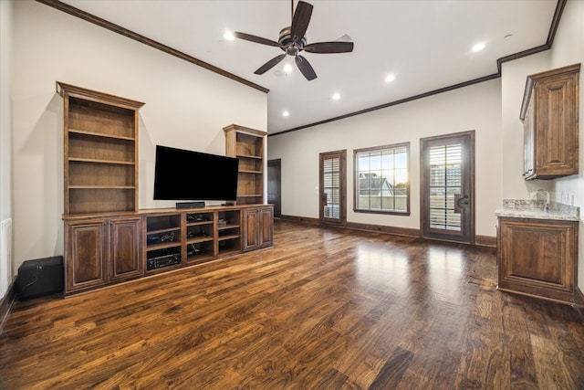 unfurnished living room featuring dark wood-type flooring, ceiling fan, and crown molding