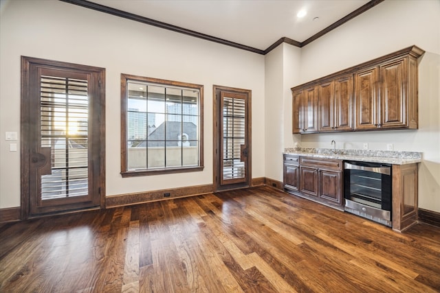 interior space featuring wine cooler, dark hardwood / wood-style flooring, light stone countertops, and crown molding