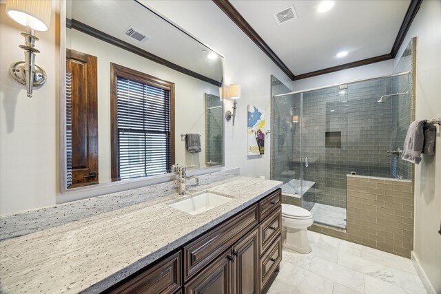 bathroom with a shower with door, vanity, toilet, and ornamental molding