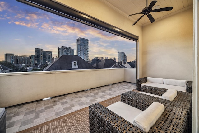 balcony at dusk featuring ceiling fan