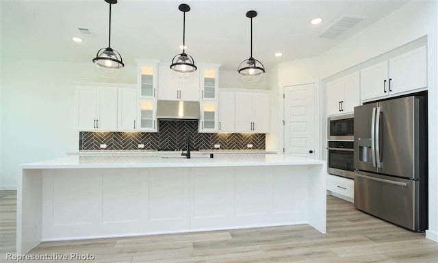 kitchen featuring decorative light fixtures, appliances with stainless steel finishes, and white cabinetry