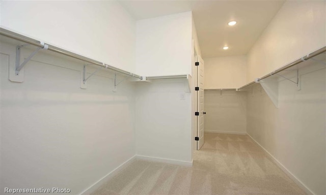 walk in closet featuring light colored carpet