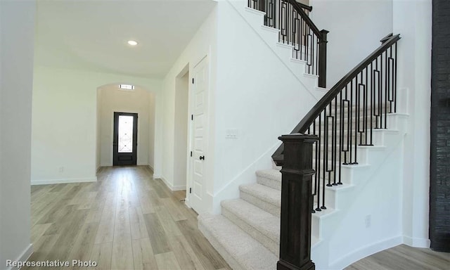 foyer with a towering ceiling and light hardwood / wood-style flooring