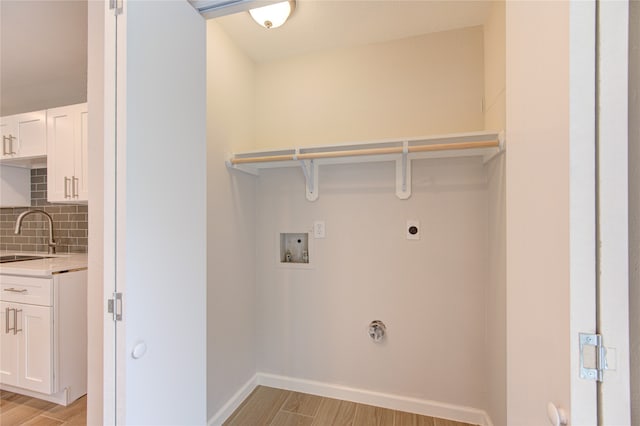 laundry room with washer hookup, electric dryer hookup, sink, and light hardwood / wood-style flooring