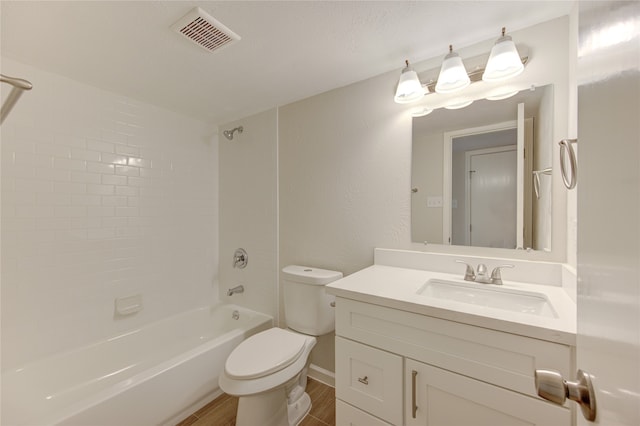 full bathroom featuring hardwood / wood-style flooring, vanity, tiled shower / bath combo, and toilet