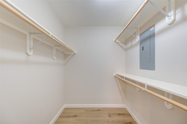 spacious closet featuring electric panel and wood-type flooring