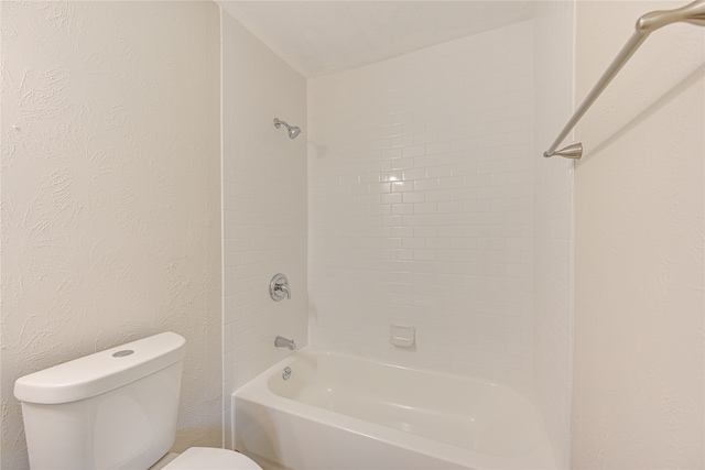 bathroom featuring tiled shower / bath combo and toilet