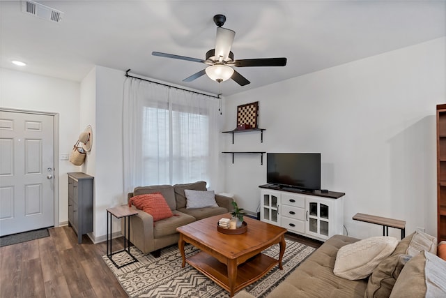 living room featuring ceiling fan and dark hardwood / wood-style flooring