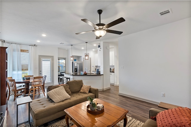 living room with dark hardwood / wood-style floors and ceiling fan