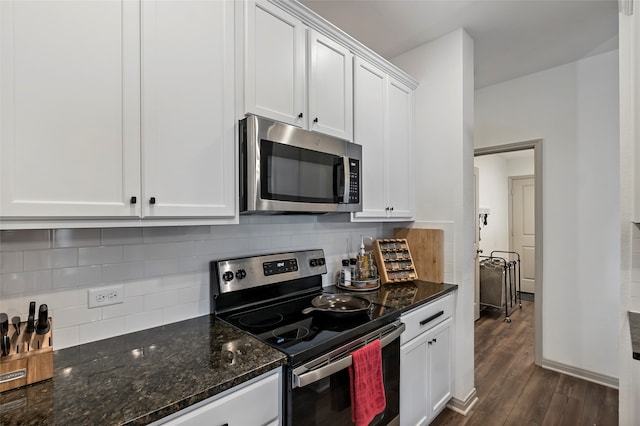 kitchen featuring white cabinets, stainless steel appliances, dark hardwood / wood-style floors, and dark stone counters