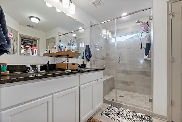 bathroom with a shower with door and vanity